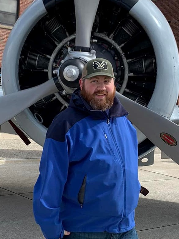 kyle standing infront of a plane